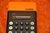 Taschenrechner Omron 86 in orange + Anleitung + Etui