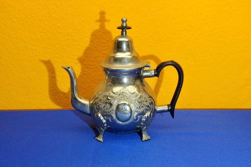 Oriental metal teapot with peacock branding